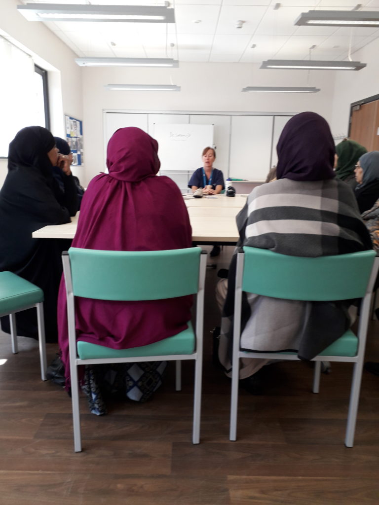 Photo of people sitting at a table for Conversation Club