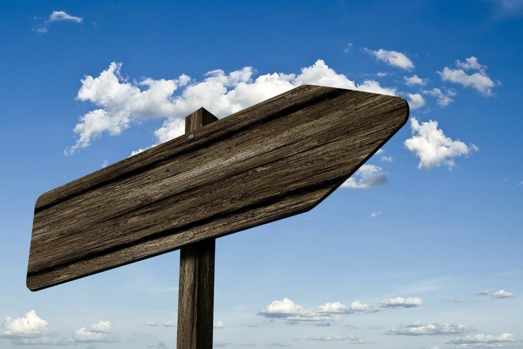 photo of a blank signpost against a blue sky