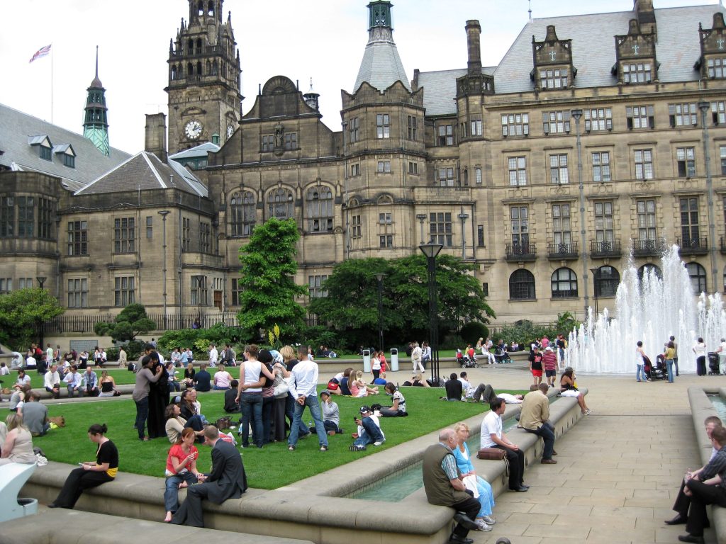 Photo of people sitting in Sheffield Peace Gardens with Town Hall behind