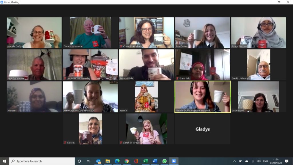 Screenshot of a Zoom call with a number of people holding up cups of tea
