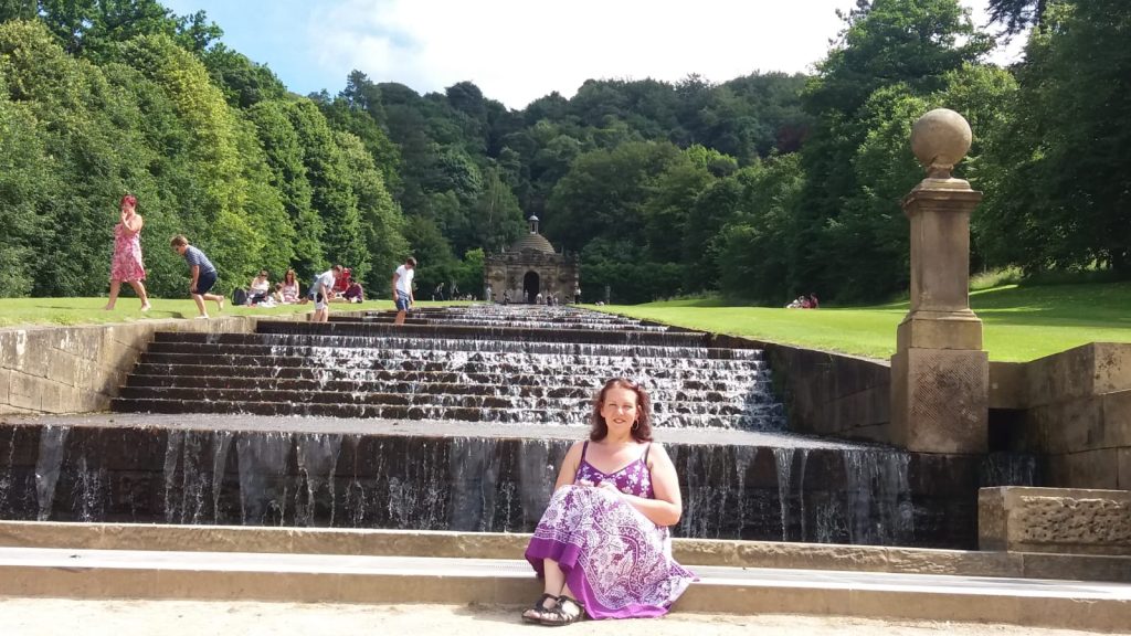 Photo of woman sitting by a fountain