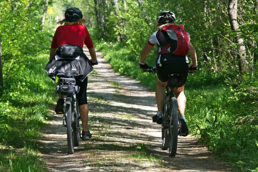 photo of 2 women riding bikes on a country lane