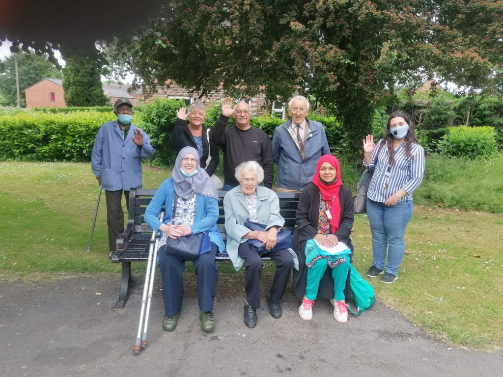photo of 8 people standing together and waving