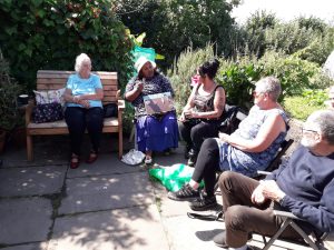 photo of 5 people doing artwork at allotment in sunshine
