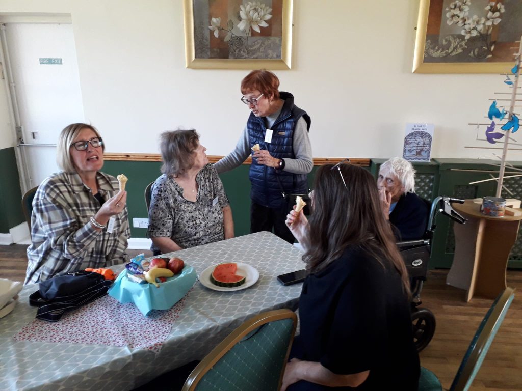 people seated around tables at a dementia cafe