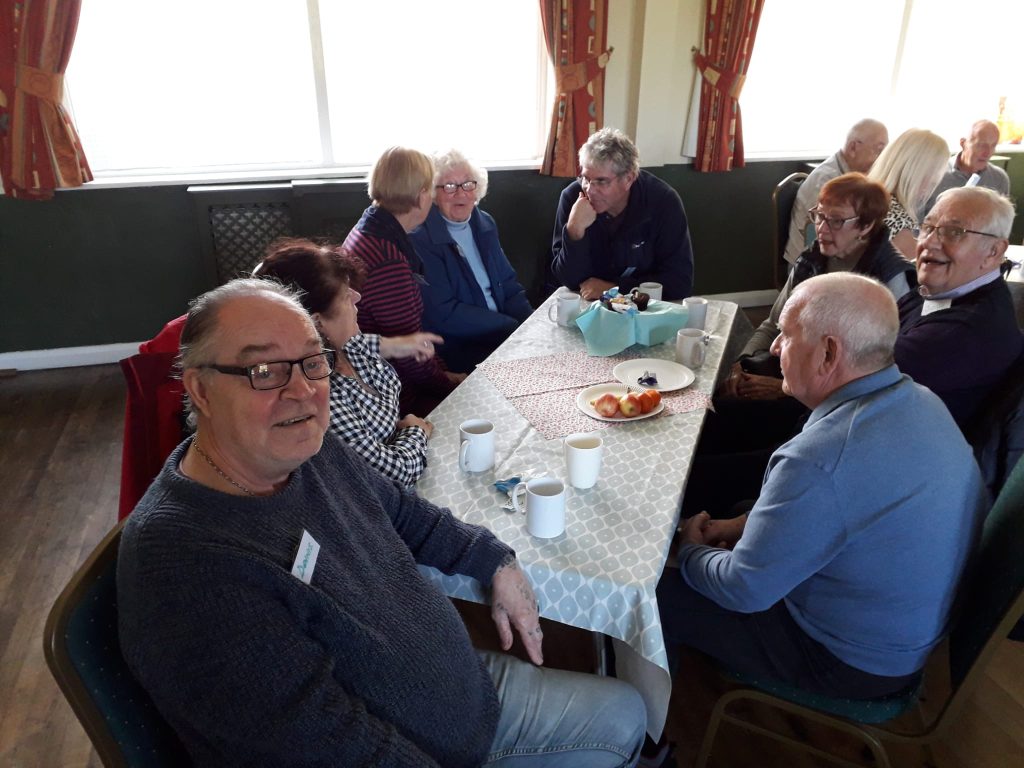 people seated around tables at a dementia cafe