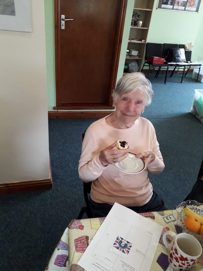 seated woman eating a scone