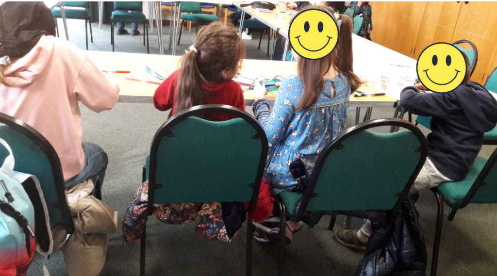 children sitting round a table with their backs to the camera