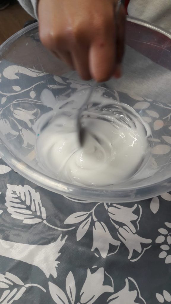 white slime being mixed in a bowl