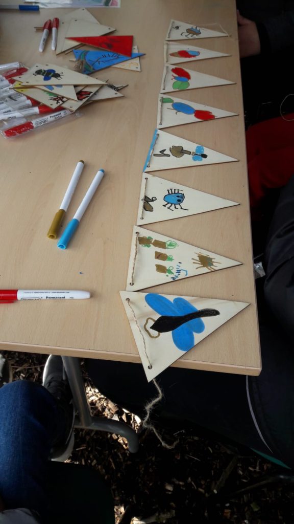 wooden bunting on a table coloured by pictures done by children