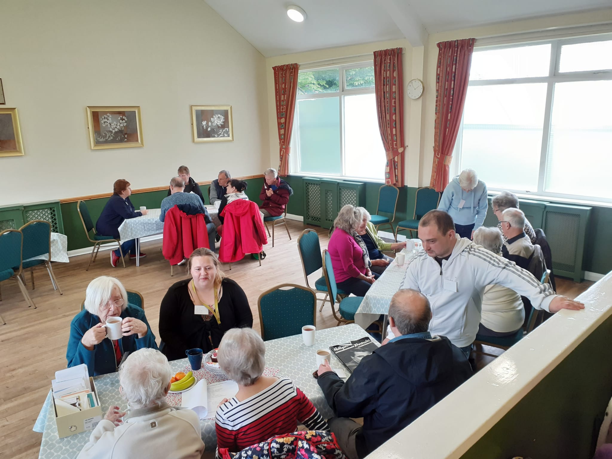 people seated around tables at a dementia cafe event
