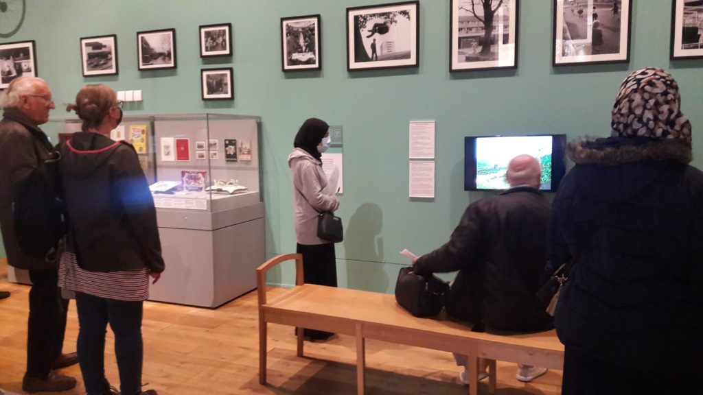 People standing in a museum gallery watching a screen