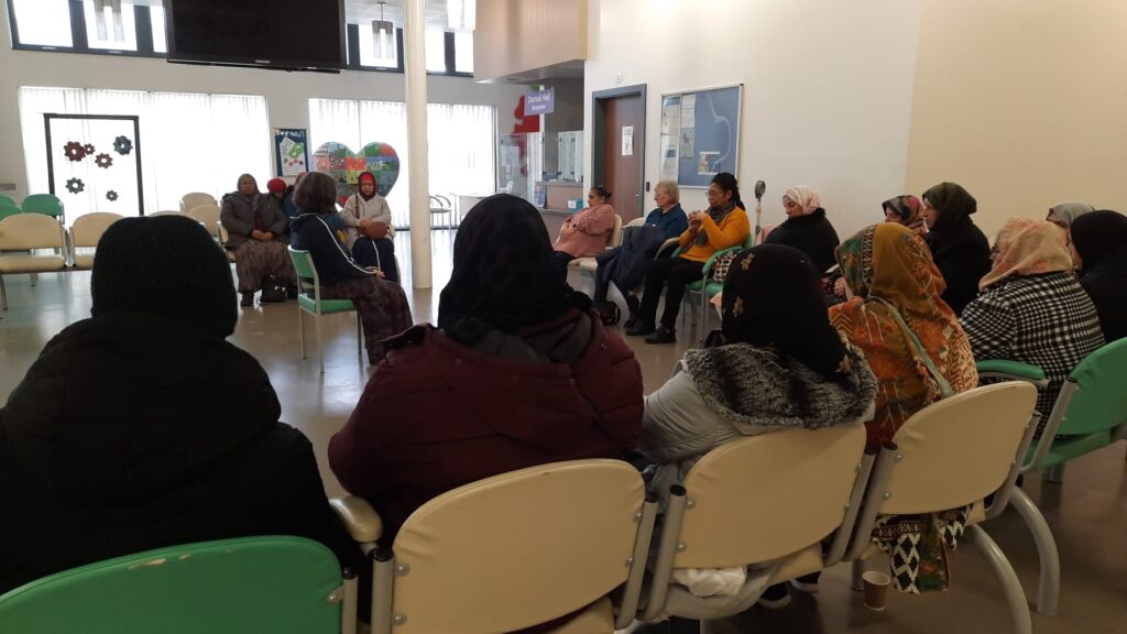 People seated around the edges of a GP waiting room