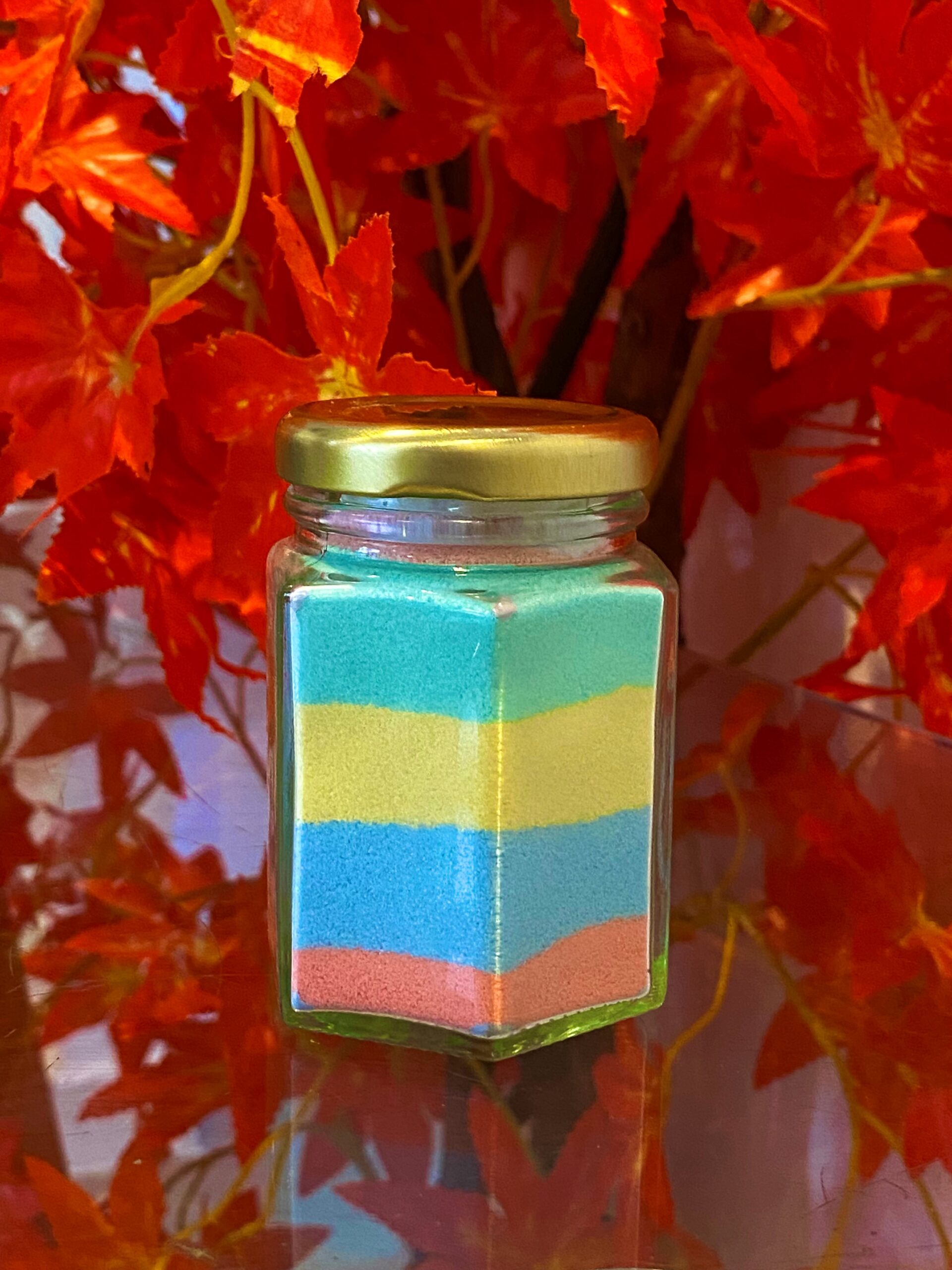 Jar filled with different coloured layers of sand.
