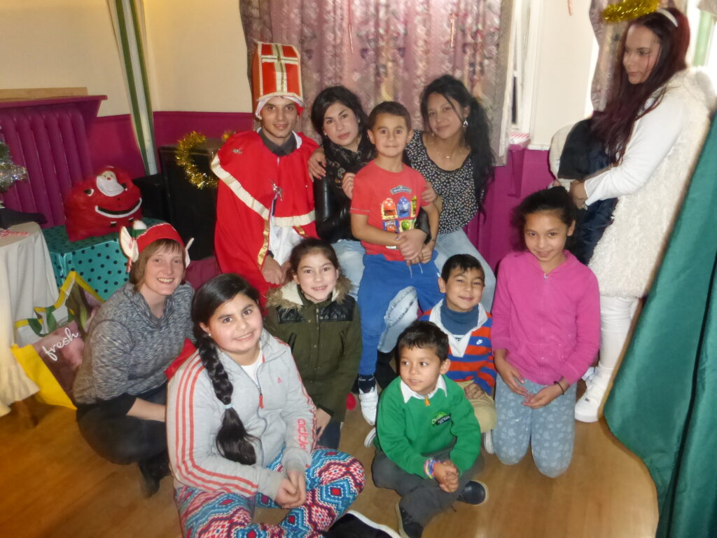 group of children smiling to camera, some dressed up in Christmas outfits