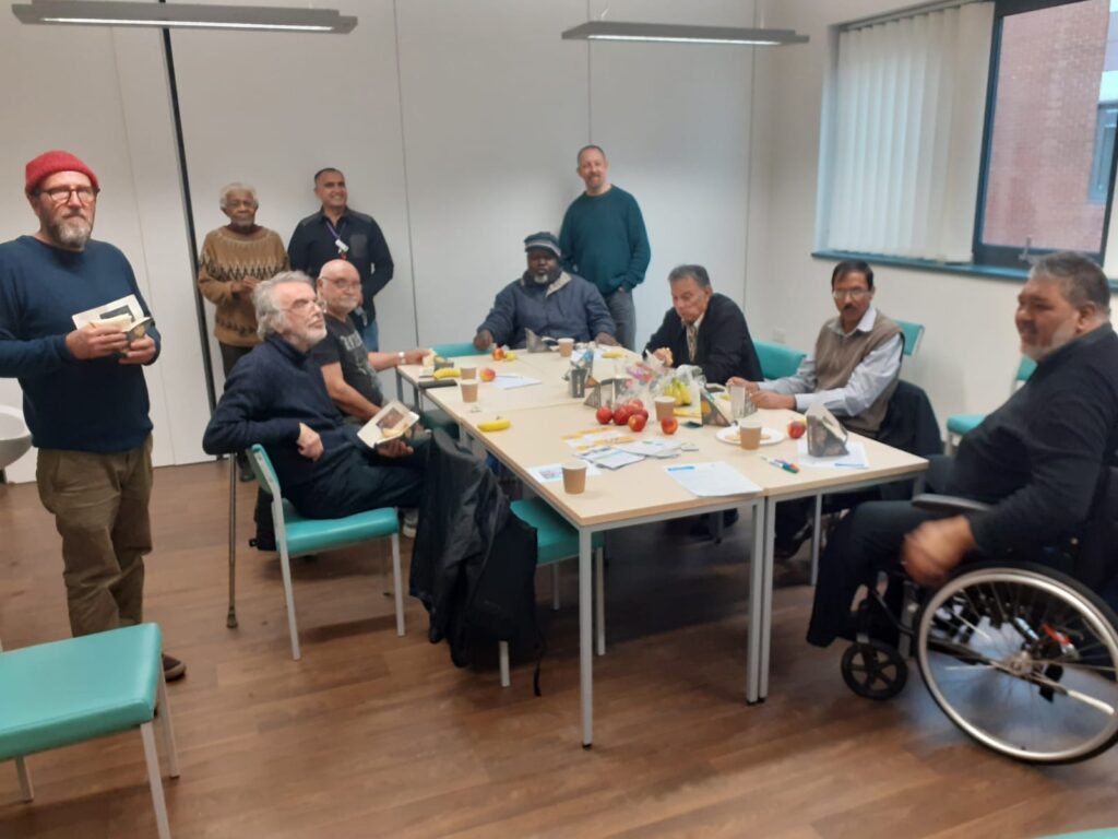 Meeting room of men standing and seated together around a table