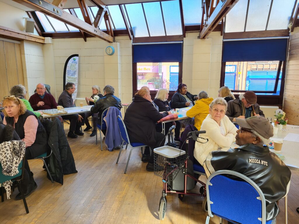 people seated around tables in a church hall