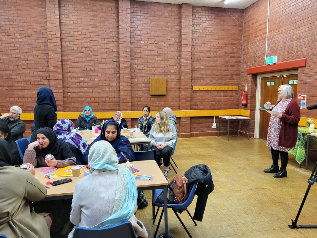 people seated around tables in a community hall