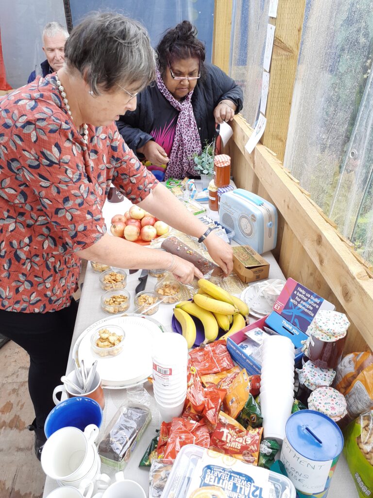 2 women lean over a long table of party food