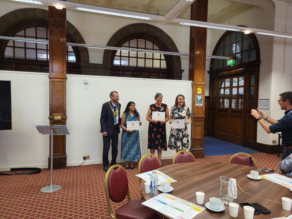 3 women holding certificates and smiling to camera, standing next to the Lord Mayor of Sheffield