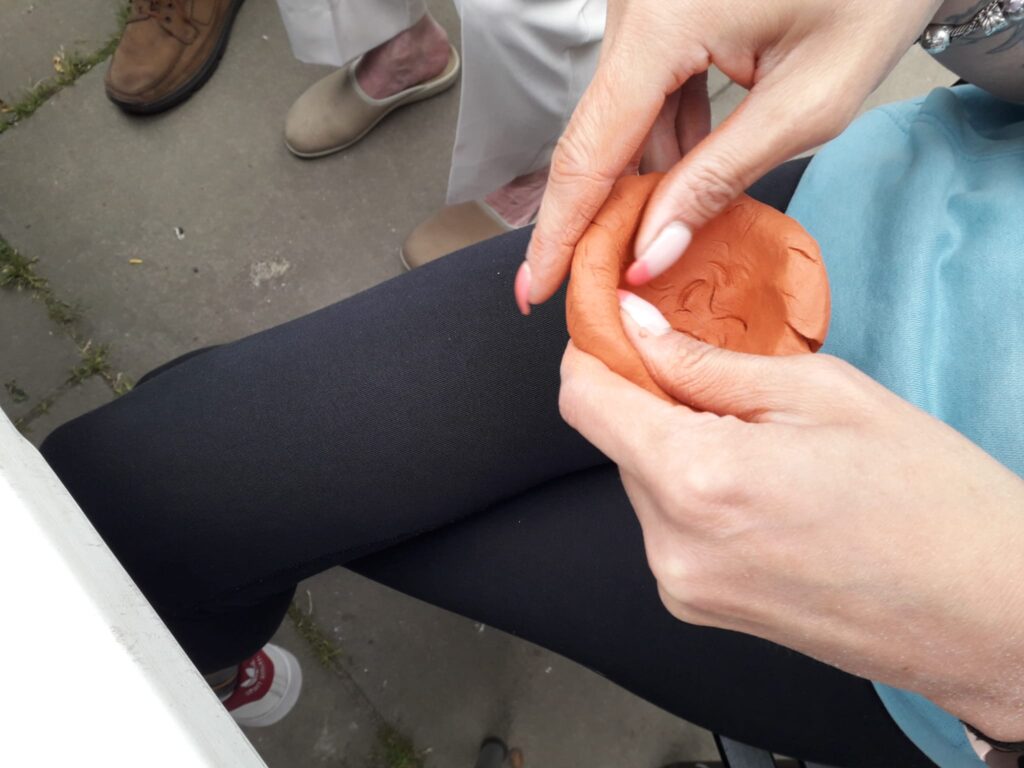 person's hands moulding some clay