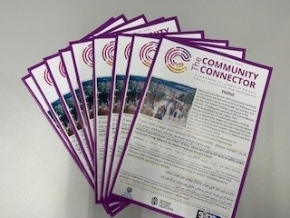 a pile of Community Connector newsletters