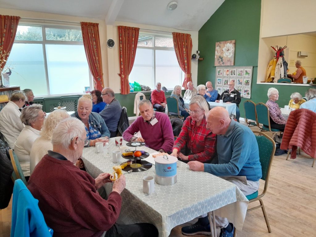 people seated around tables at a dementia cafe