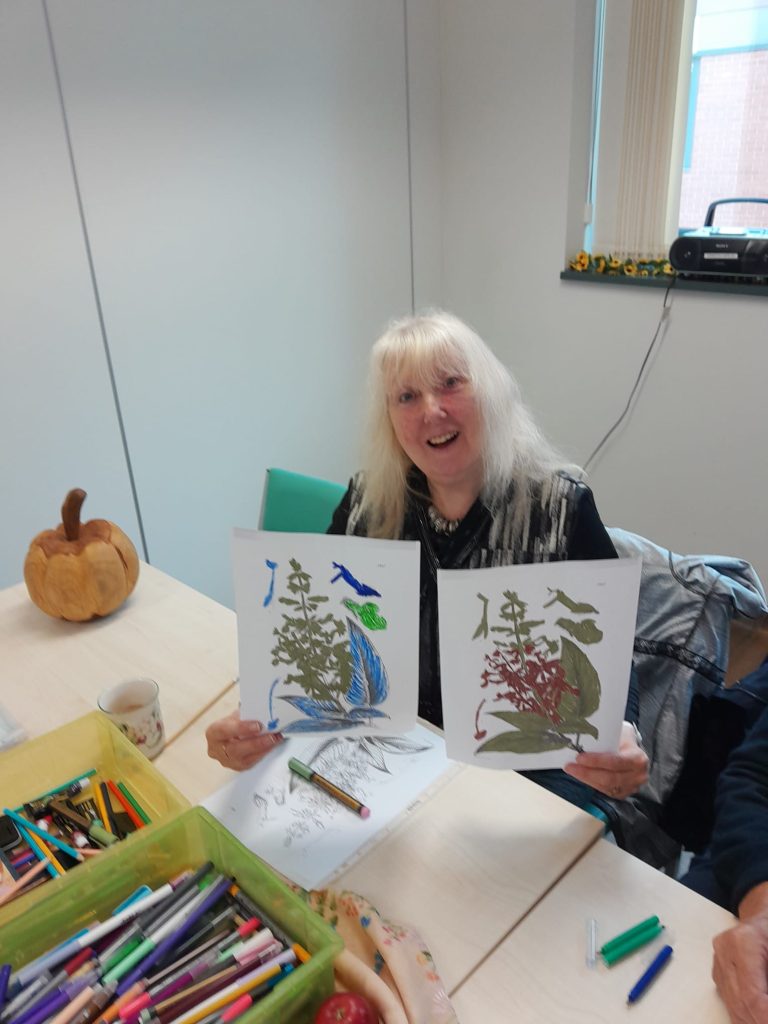 smiling woman holding coloured in pictures