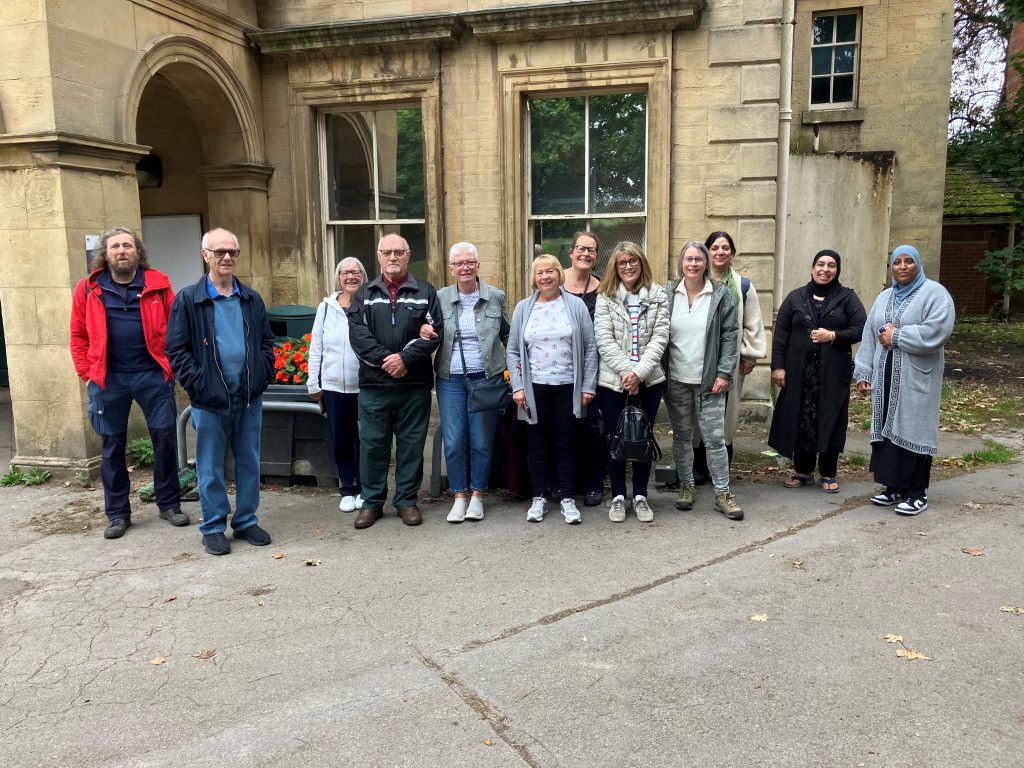 group of people smiling to camera outside a building