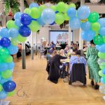 People sitting together framed by a balloon arch
