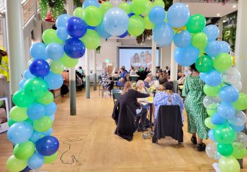 People sitting together framed by a balloon arch